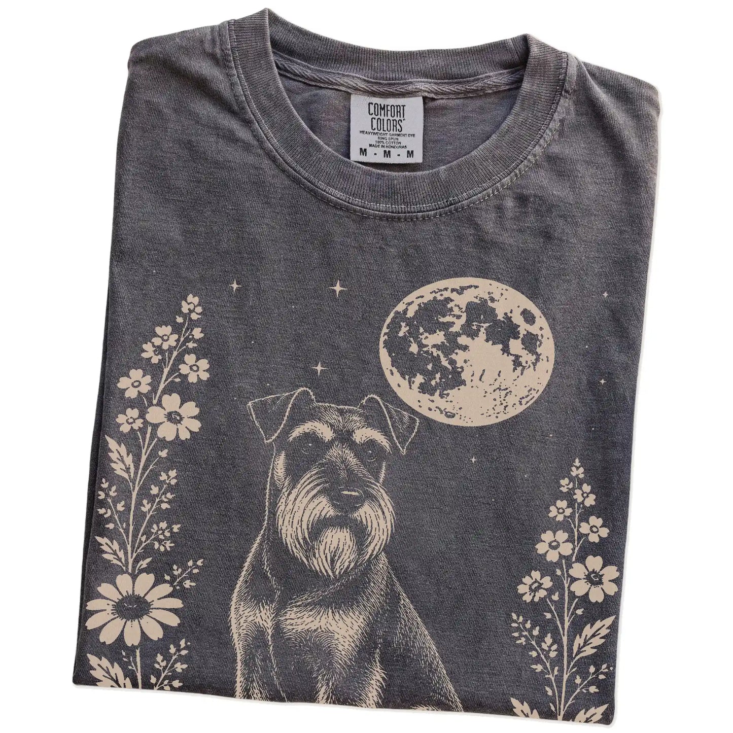 Folded Pepper Comfort Colors® T-shirt showing Standard Schnauzer framed by flowers beneath the moon