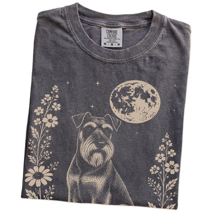 Folded Pepper Comfort Colors® T-shirt showing Standard Schnauzer framed by flowers beneath the moon