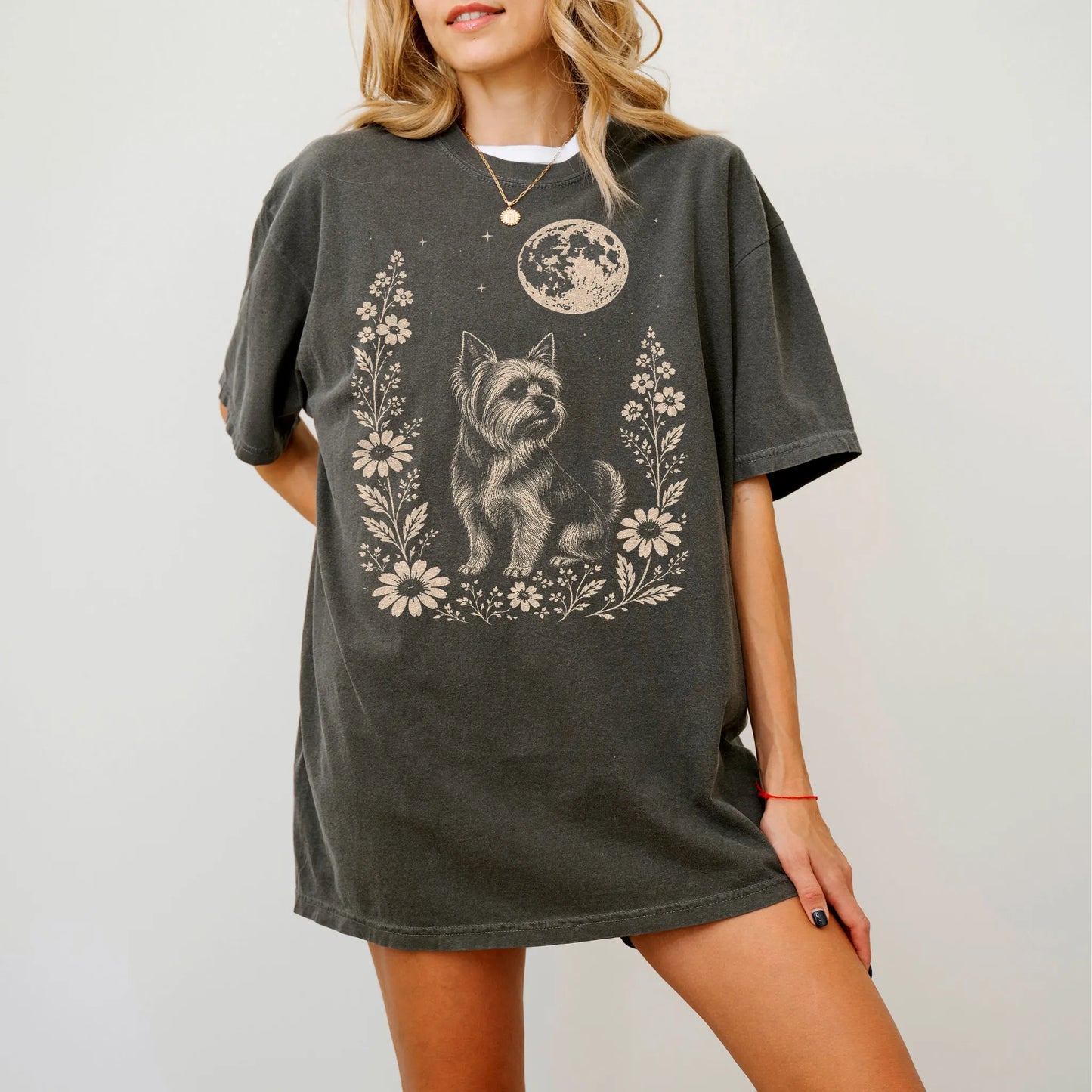 Model wearing a Pepper Comfort Colors® T-shirt featuring Yorkie framed by flowers beneath the moon