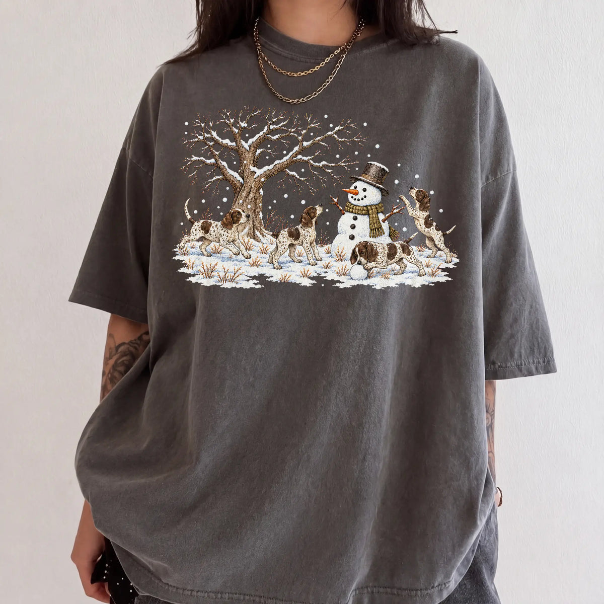 Pointer puppies playing in snow with a snowman on a Pepper T-shirt worn by a model