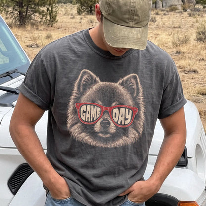 Model wearing a Pepper Comfort Colors® T-shirt with pomeranian wearing red game day sunglasses