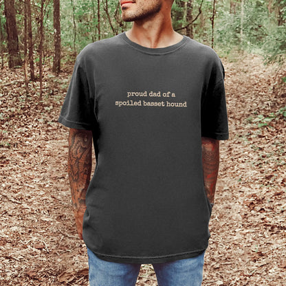 Model wearing a Pepper Comfort Colors® T-shirt with proud dad of a spoiled basset hound lettering