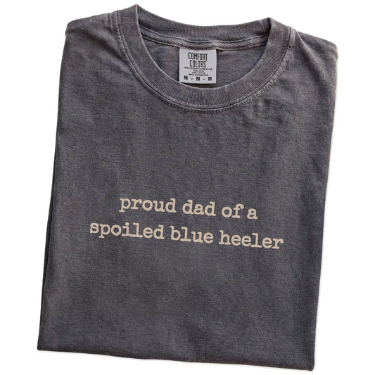 Folded Pepper Comfort Colors® T-shirt showing proud dad of a spoiled blue heeler lettering