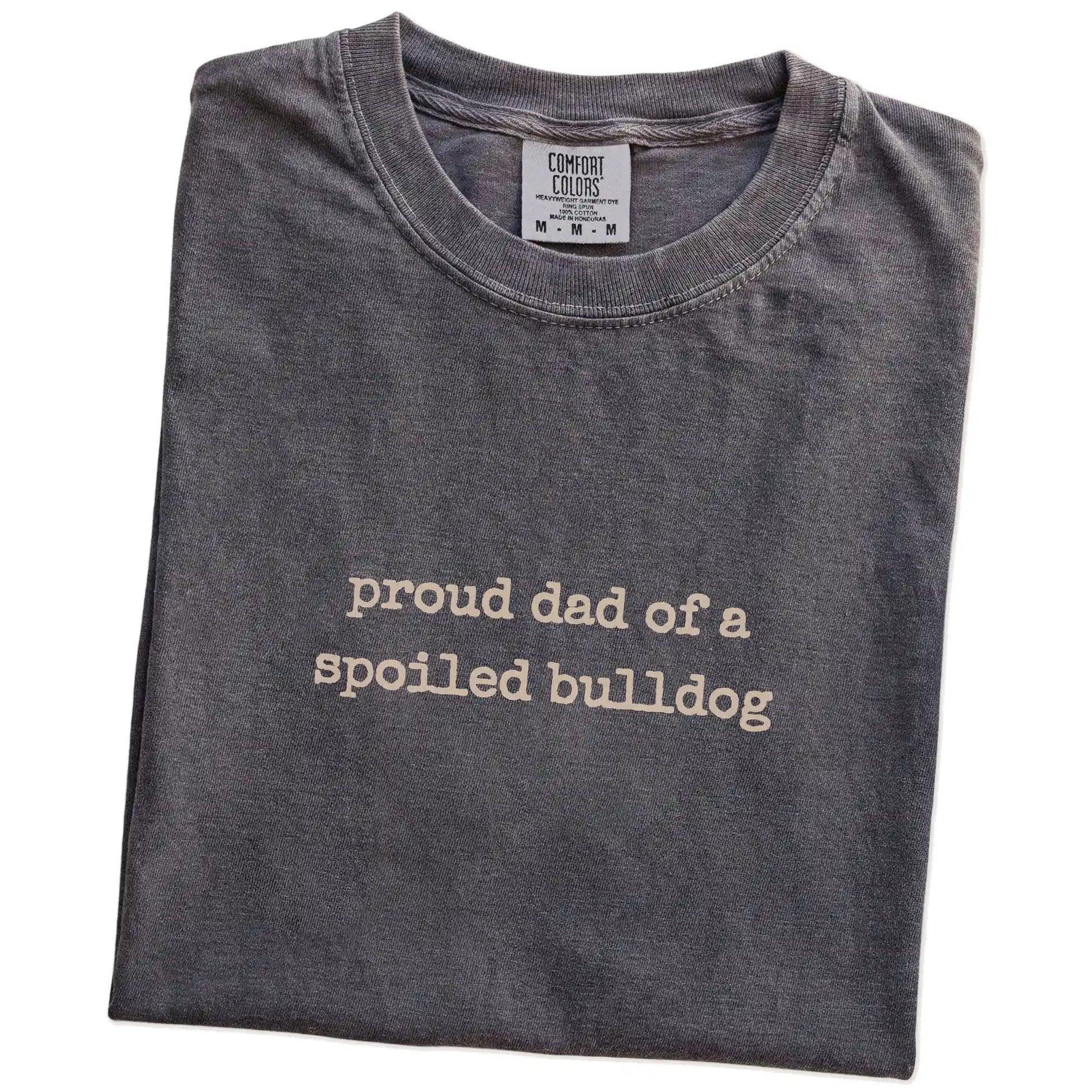 Folded Pepper Comfort Colors® T-shirt showing proud dad of a spoiled bulldog lettering
