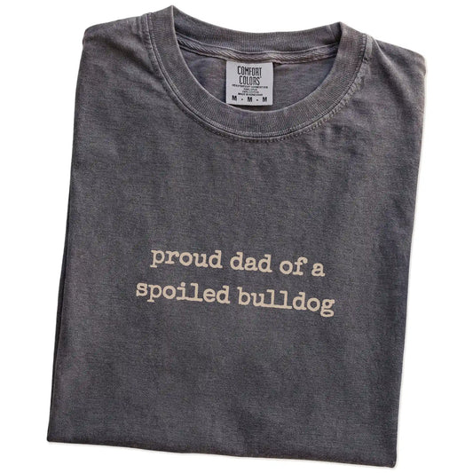 Folded Pepper Comfort Colors® T-shirt showing proud dad of a spoiled bulldog lettering