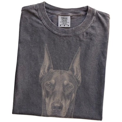 Folded Pepper Comfort Colors® T-shirt showing a realistic drawing of a Doberman