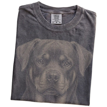 Folded Pepper Comfort Colors® T-shirt showing a realistic drawing of a Rottweiler