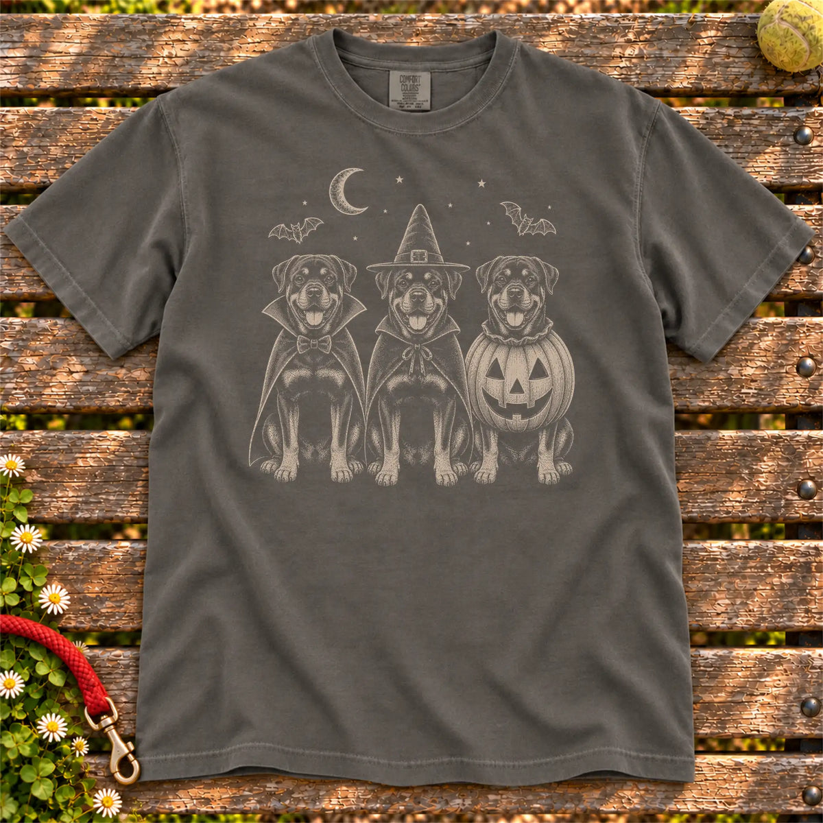 Three Rottweiler dogs dressed for Halloween beneath bats and a crescent moon on a Pepper Comfort Colors® T-shirt