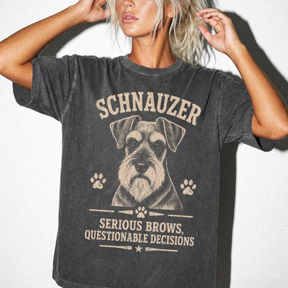 Model wearing a Pepper Comfort Colors® T-shirt featuring Schnauzer design with “Serious Brows, Questionable Decisions” letter