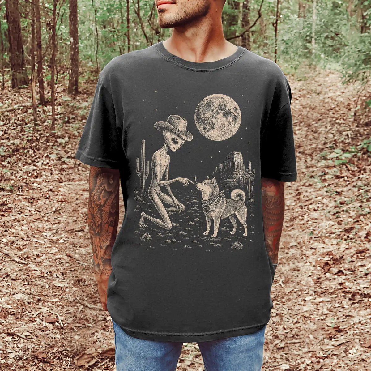 Model wearing a Pepper Comfort Colors® T-shirt with cowboy alien fist-bumping a shiba inu beneath the moon