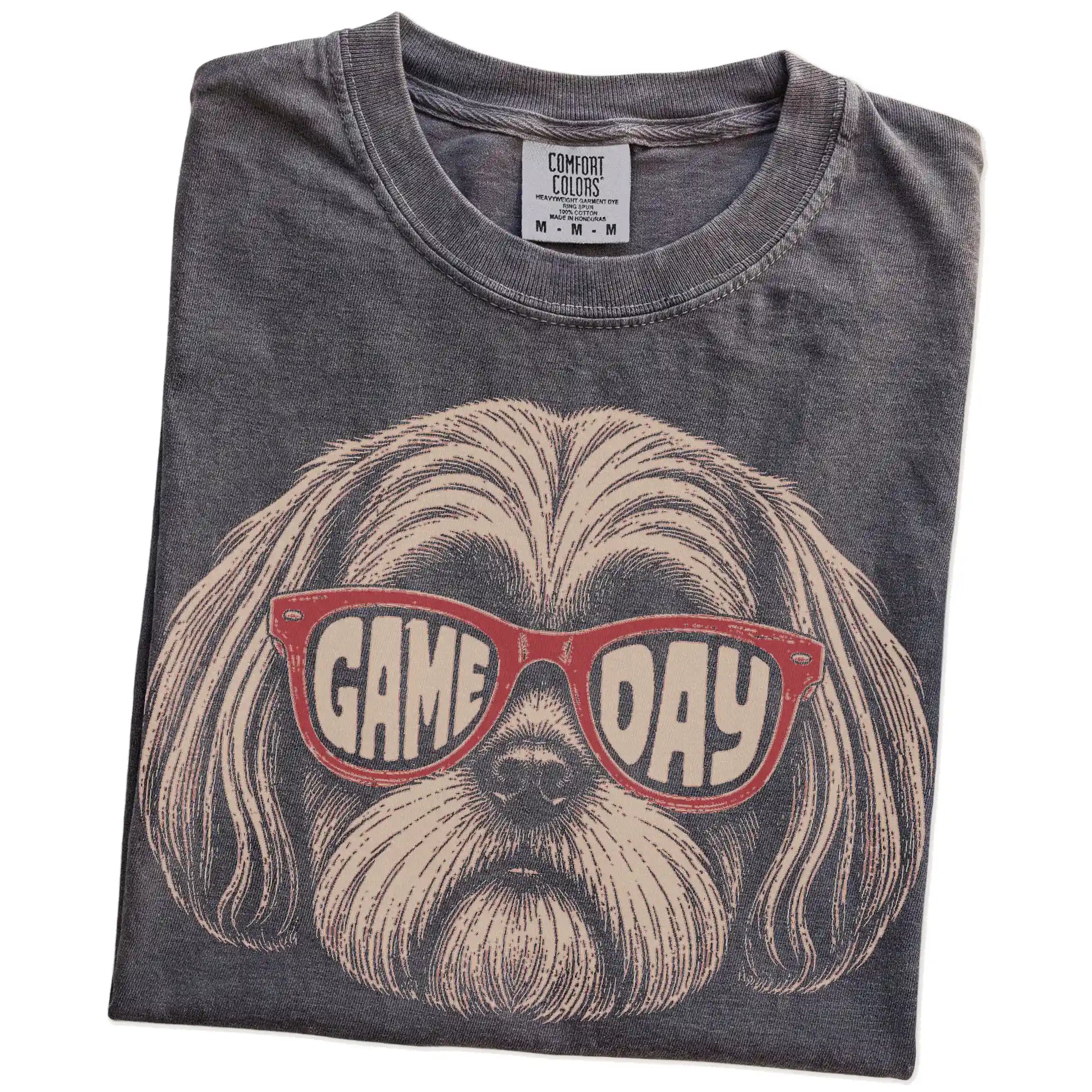 Folded Pepper Comfort Colors® T-shirt showing shih tzu wearing red game day sunglasses