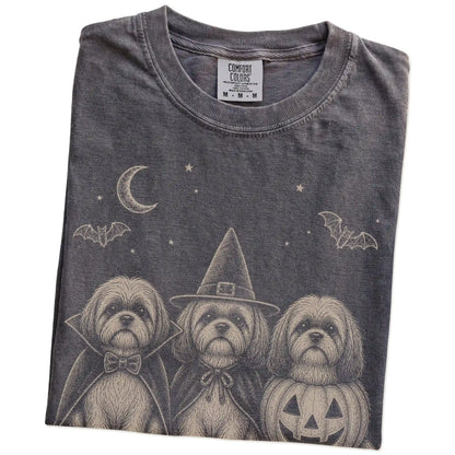 Folded Pepper Comfort Colors® T-shirt showing three Shih Tzu dogs dressed for Halloween beneath bats and a crescent moon