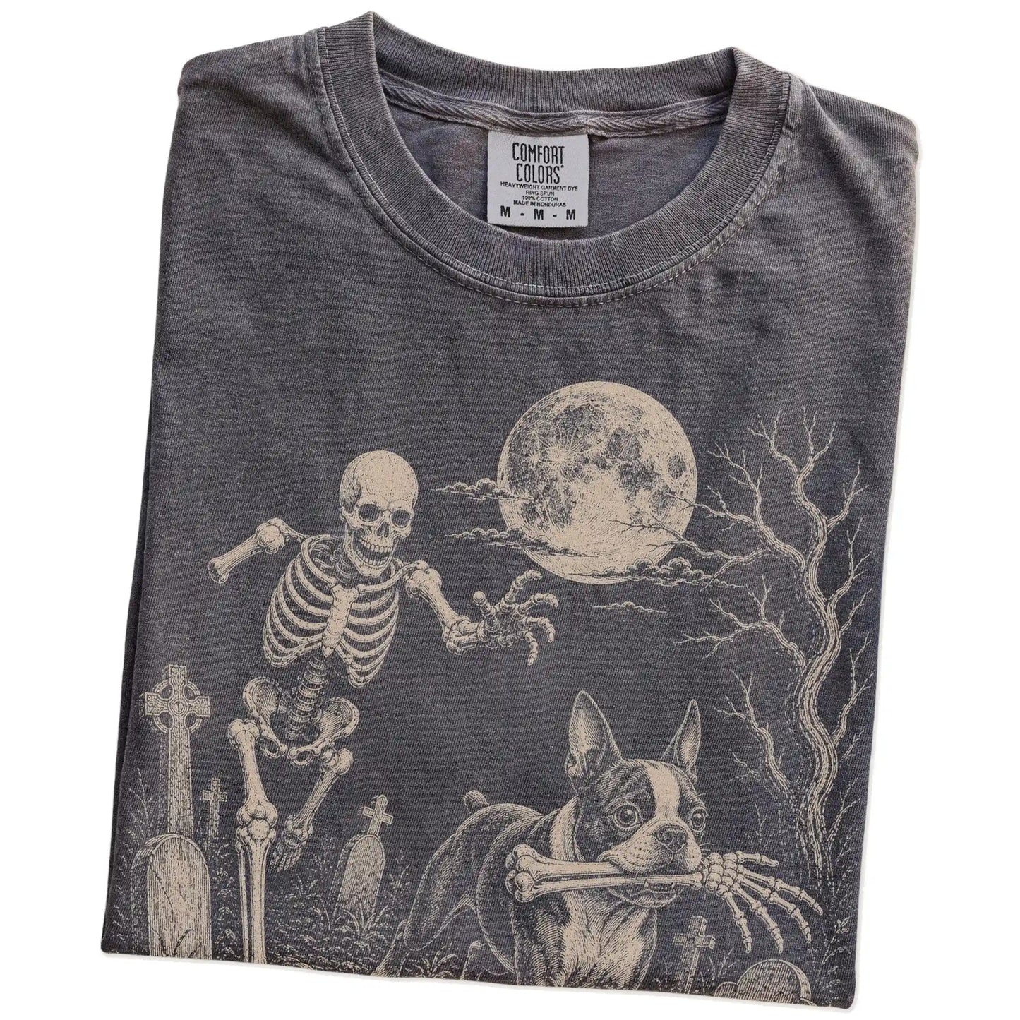 Folded Pepper Comfort Colors® T-shirt showing Boston Terrier running through a moonlit graveyard with a chasing skeleton