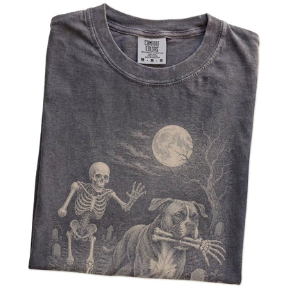 Folded Pepper Comfort Colors® T-shirt showing Boxer running through a moonlit graveyard with a chasing skeleton