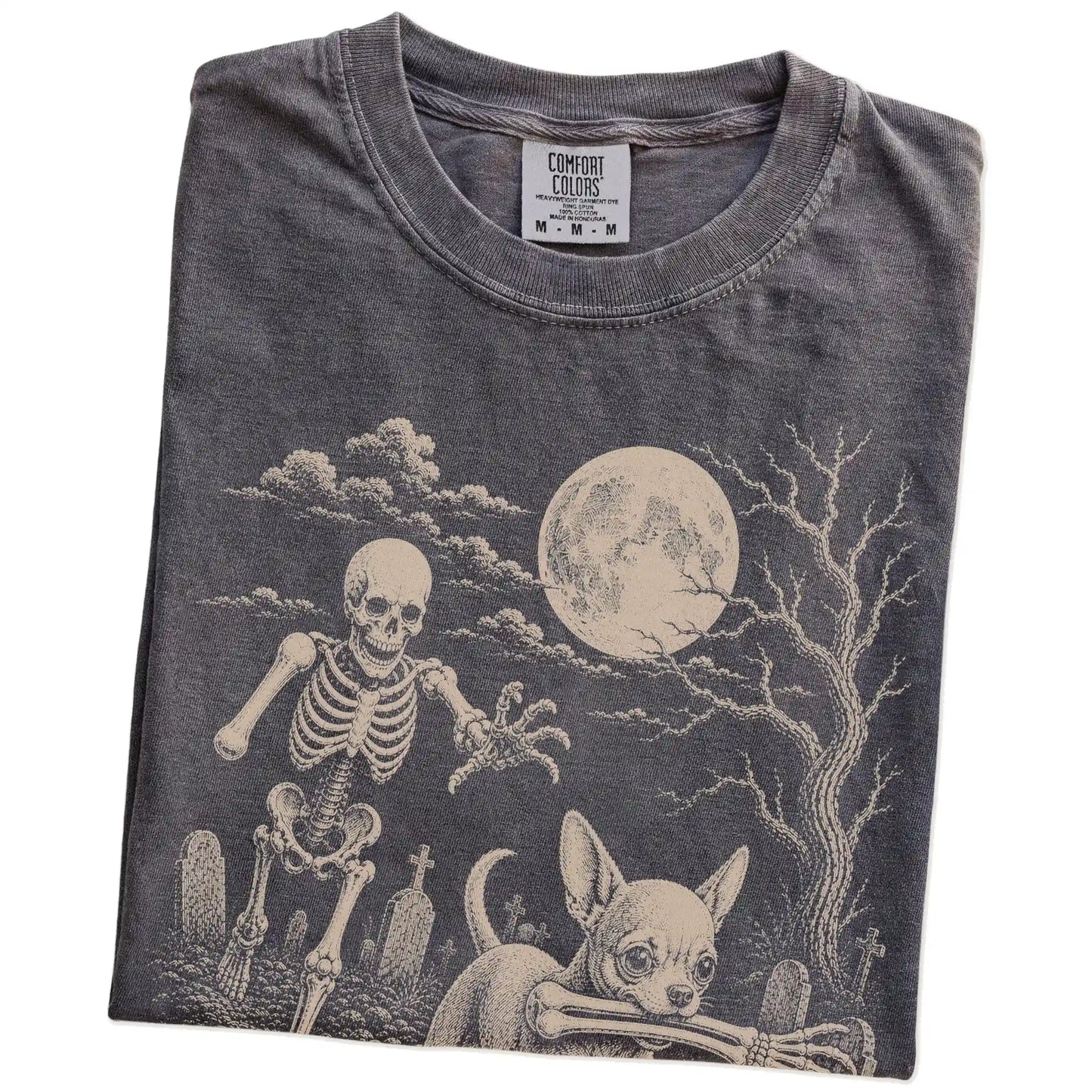 Folded Pepper Comfort Colors® T-shirt showing Chihuahua running through a moonlit graveyard with a chasing skeleton