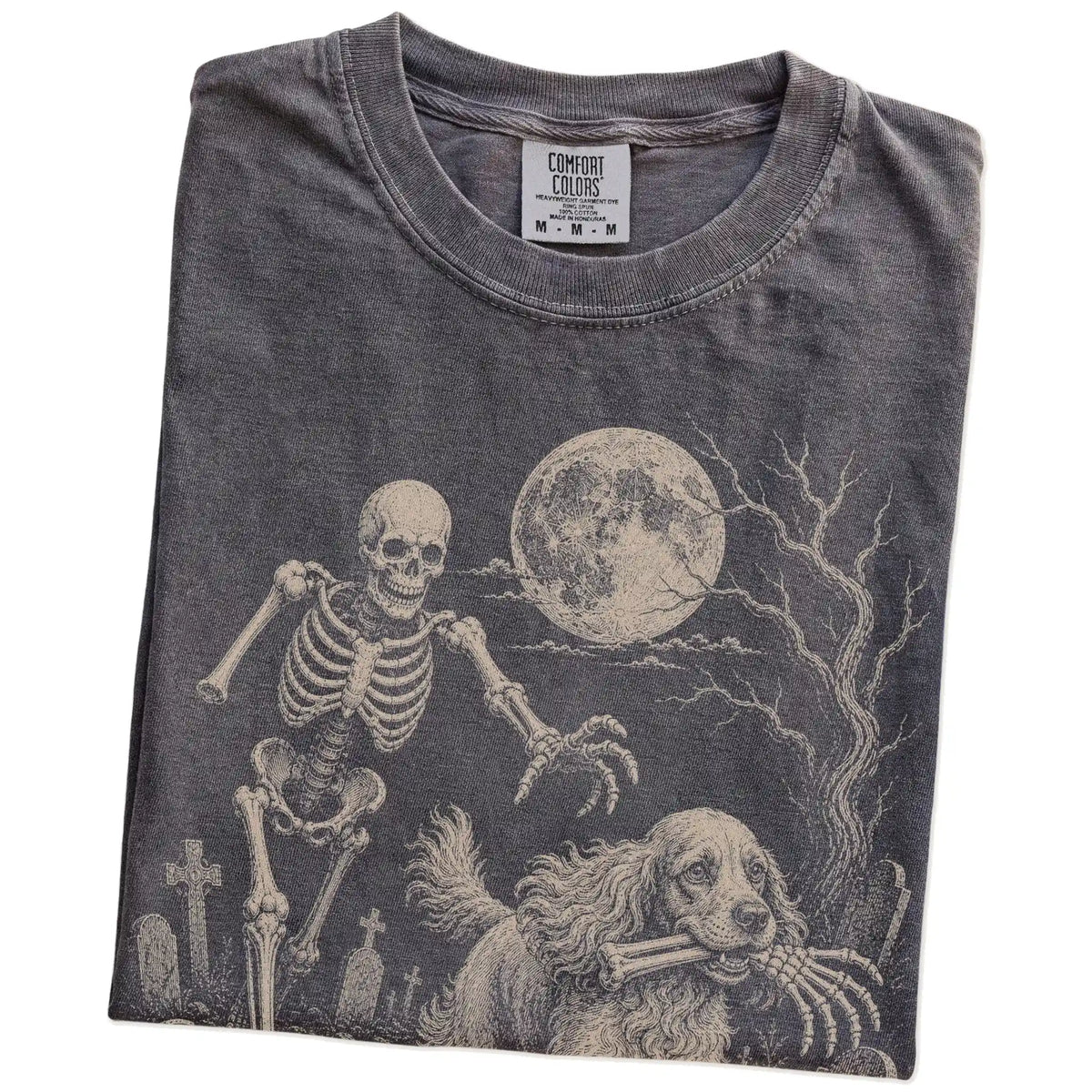 Folded Pepper Comfort Colors® T-shirt showing Cocker Spaniel running through a moonlit graveyard with a chasing skeleton