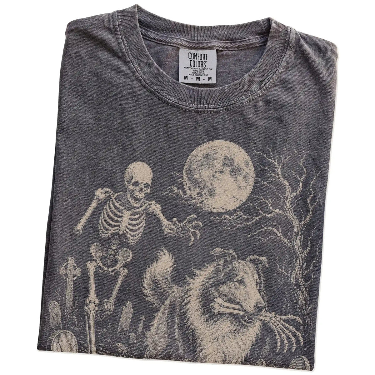 Folded Pepper Comfort Colors® T-shirt showing Collie running through a moonlit graveyard with a chasing skeleton