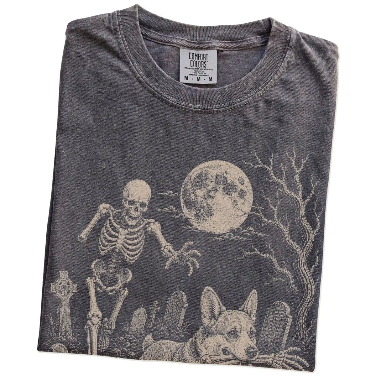 Folded Pepper Comfort Colors® T-shirt showing Corgi running through a moonlit graveyard with a chasing skeleton