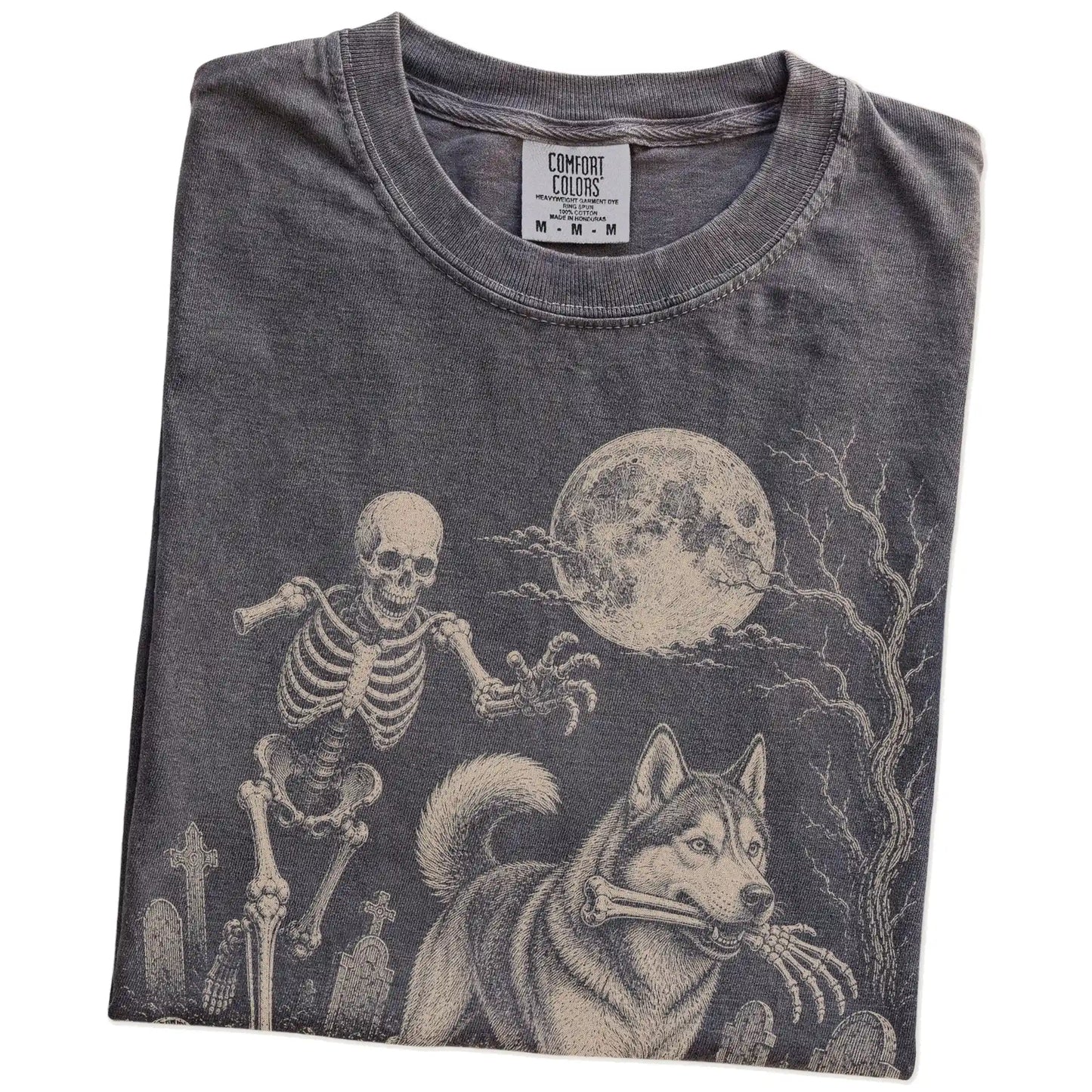 Folded Pepper Comfort Colors® T-shirt showing Husky running through a moonlit graveyard with a chasing skeleton