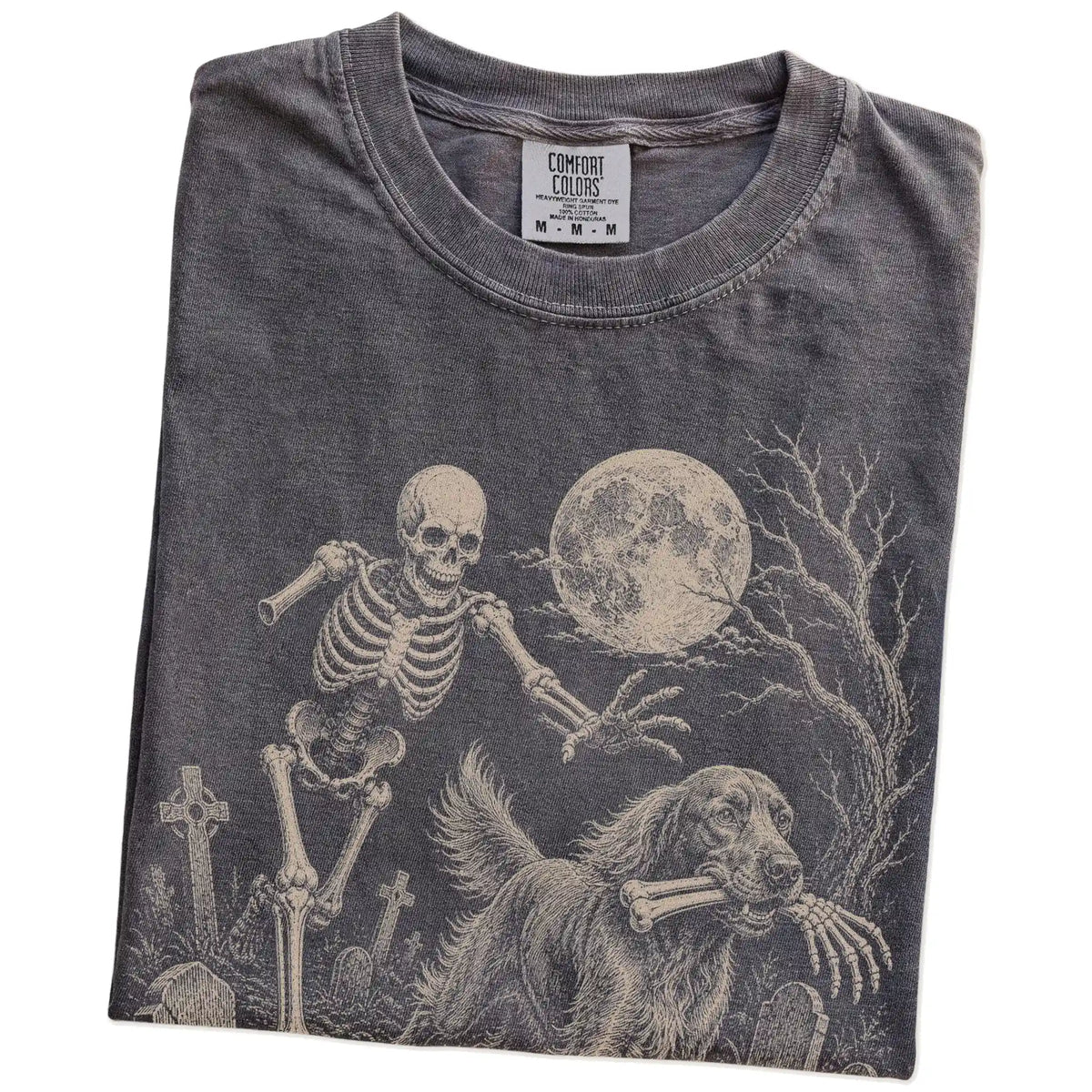 Folded Pepper Comfort Colors® T-shirt showing Irish Setter running through a moonlit graveyard with a chasing skeleton