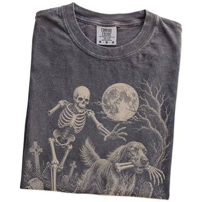Folded Pepper Comfort Colors® T-shirt showing Irish Setter running through a moonlit graveyard with a chasing skeleton