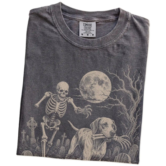 Folded Pepper Comfort Colors® T-shirt showing Pointer running through a moonlit graveyard with a chasing skeleton