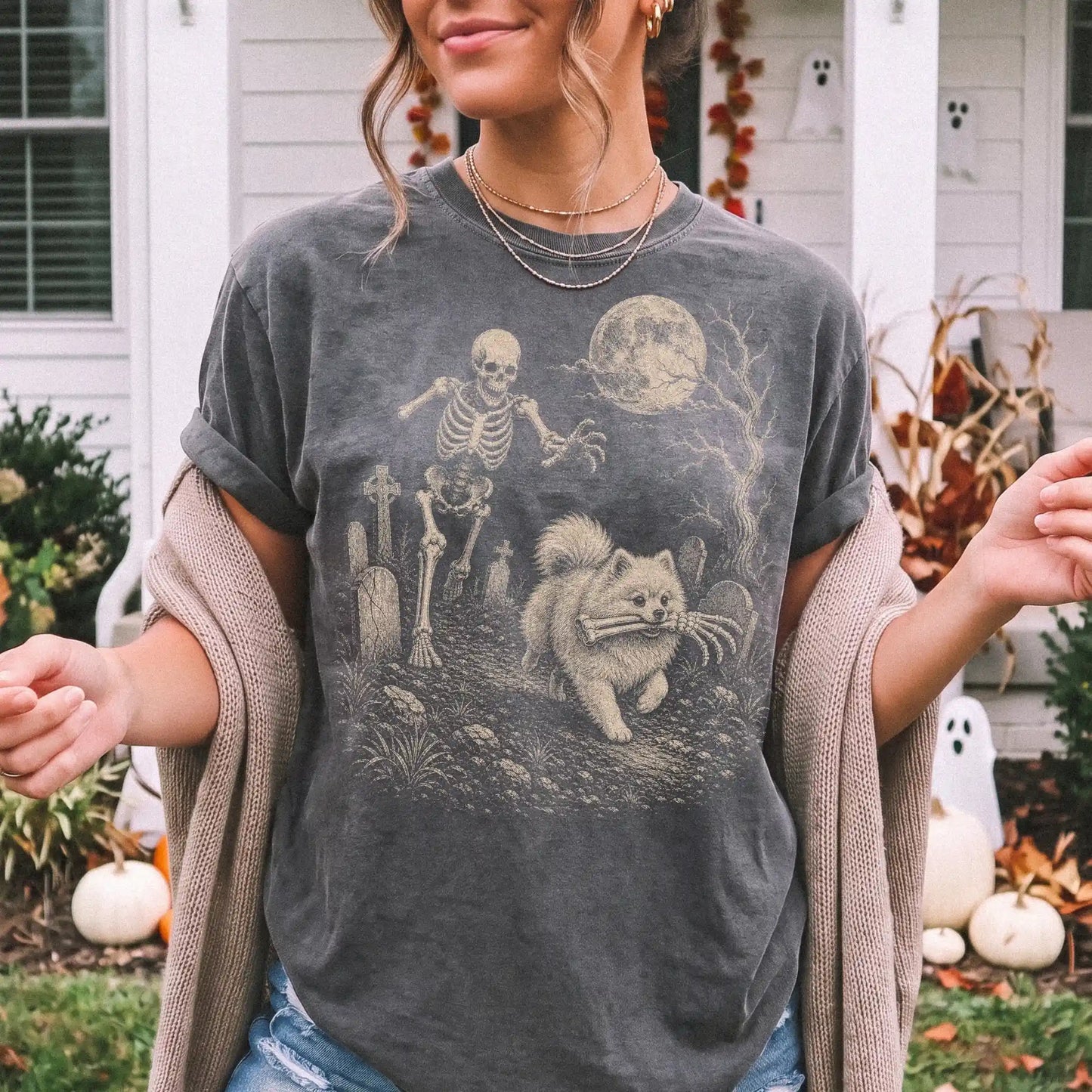 Model wearing a Pepper Comfort Colors® T-shirt showing Pomeranian running through a moonlit graveyard with a chasing skeleton