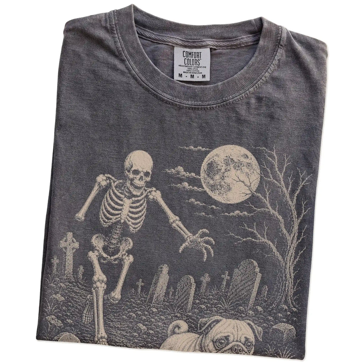 Folded Pepper Comfort Colors® T-shirt showing Pug running through a moonlit graveyard with a chasing skeleton