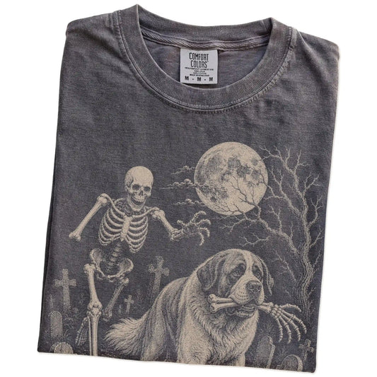 Folded Pepper Comfort Colors® T-shirt showing Saint Bernard running through a moonlit graveyard with a chasing skeleton