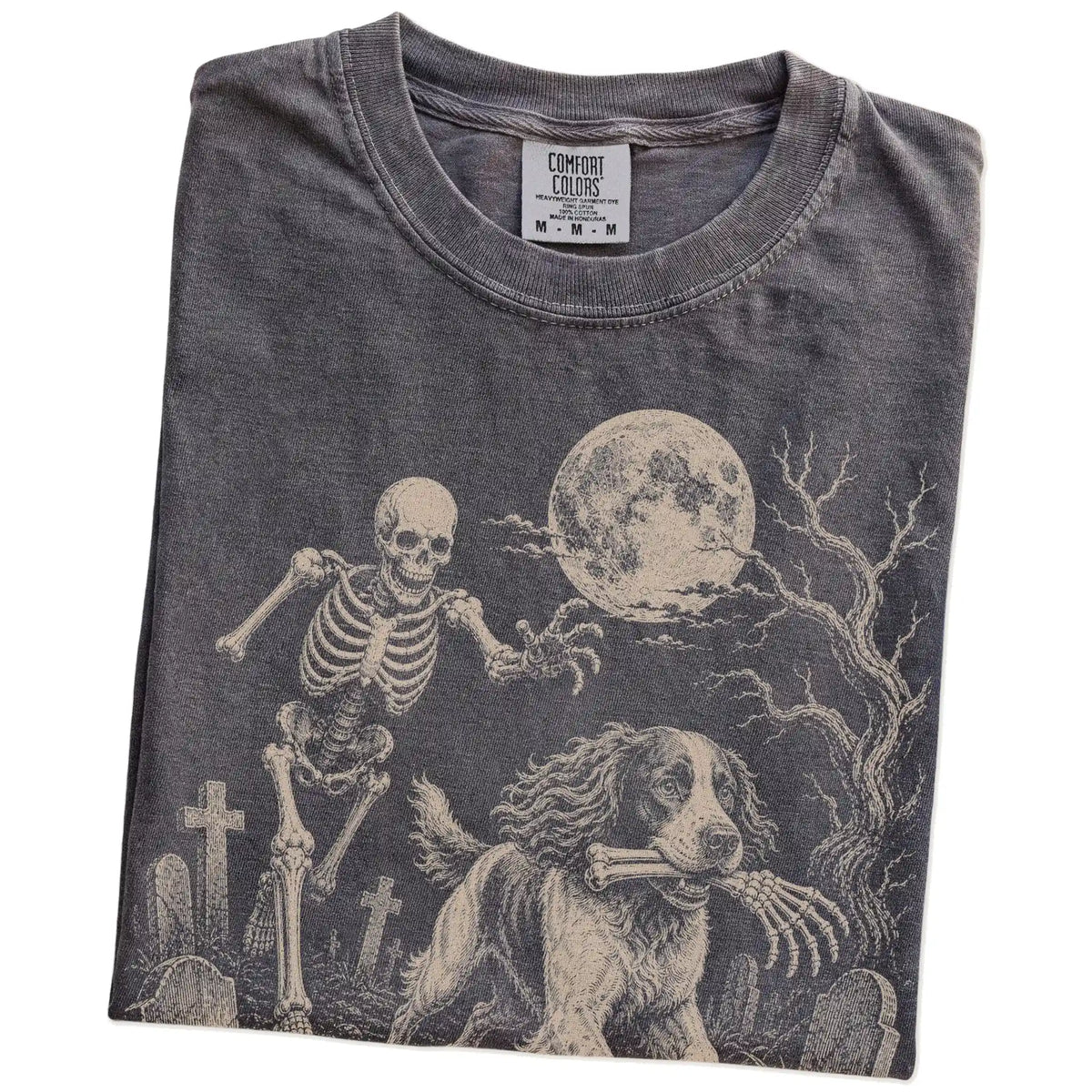 Folded Pepper Comfort Colors® T-shirt showing Springer Spaniel running through a moonlit graveyard with a chasing skeleton
