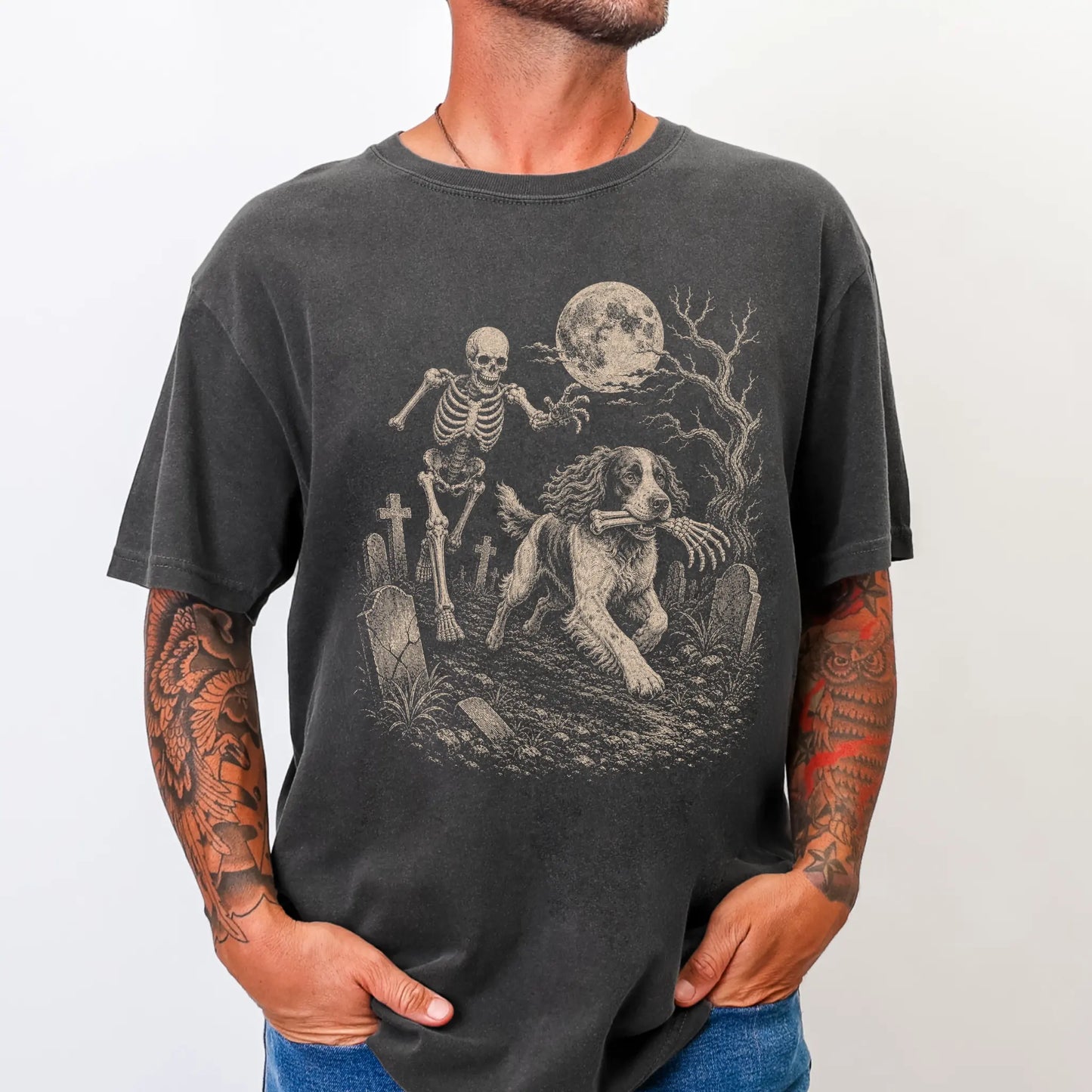 Model wearing a Pepper Comfort Colors® T-shirt showing Springer Spaniel running through a moonlit graveyard with a chasing sk