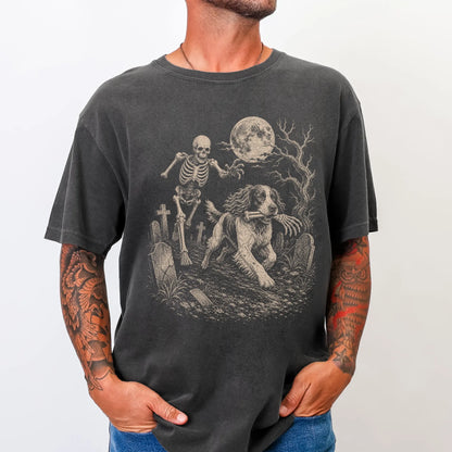 Model wearing a Pepper Comfort Colors® T-shirt showing Springer Spaniel running through a moonlit graveyard with a chasing sk