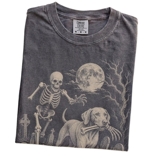 Folded Pepper Comfort Colors® T-shirt showing Vizsla running through a moonlit graveyard with a chasing skeleton
