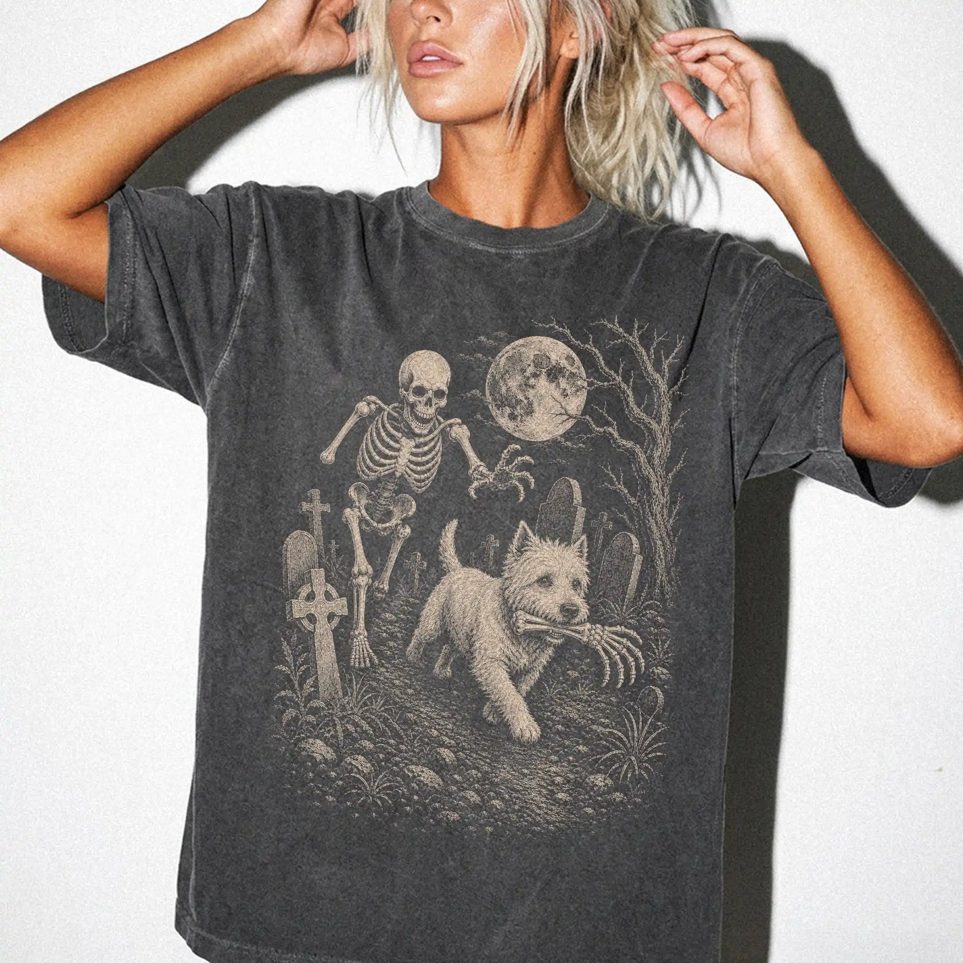 Model wearing a Pepper Comfort Colors® T-shirt showing Westie running through a moonlit graveyard with a chasing skeleton