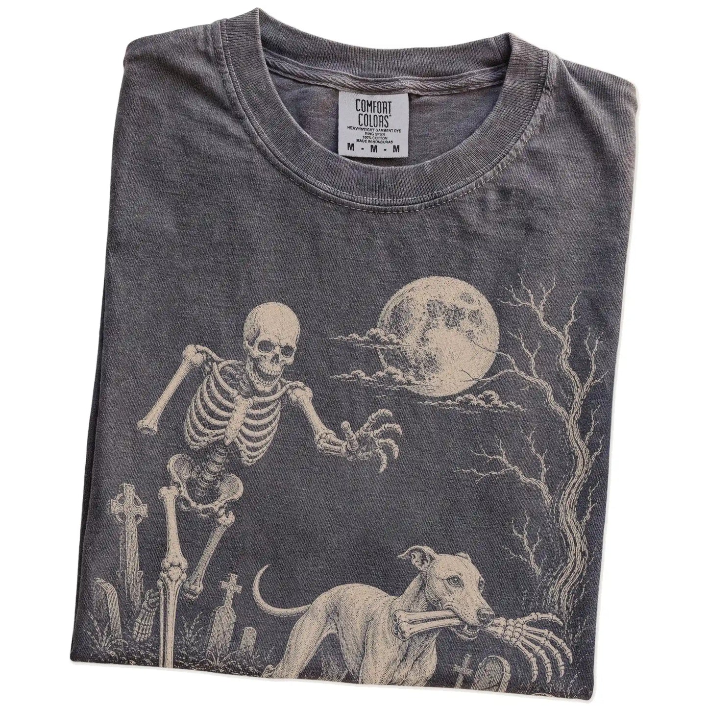 Folded Pepper Comfort Colors® T-shirt showing Whippet running through a moonlit graveyard with a chasing skeleton