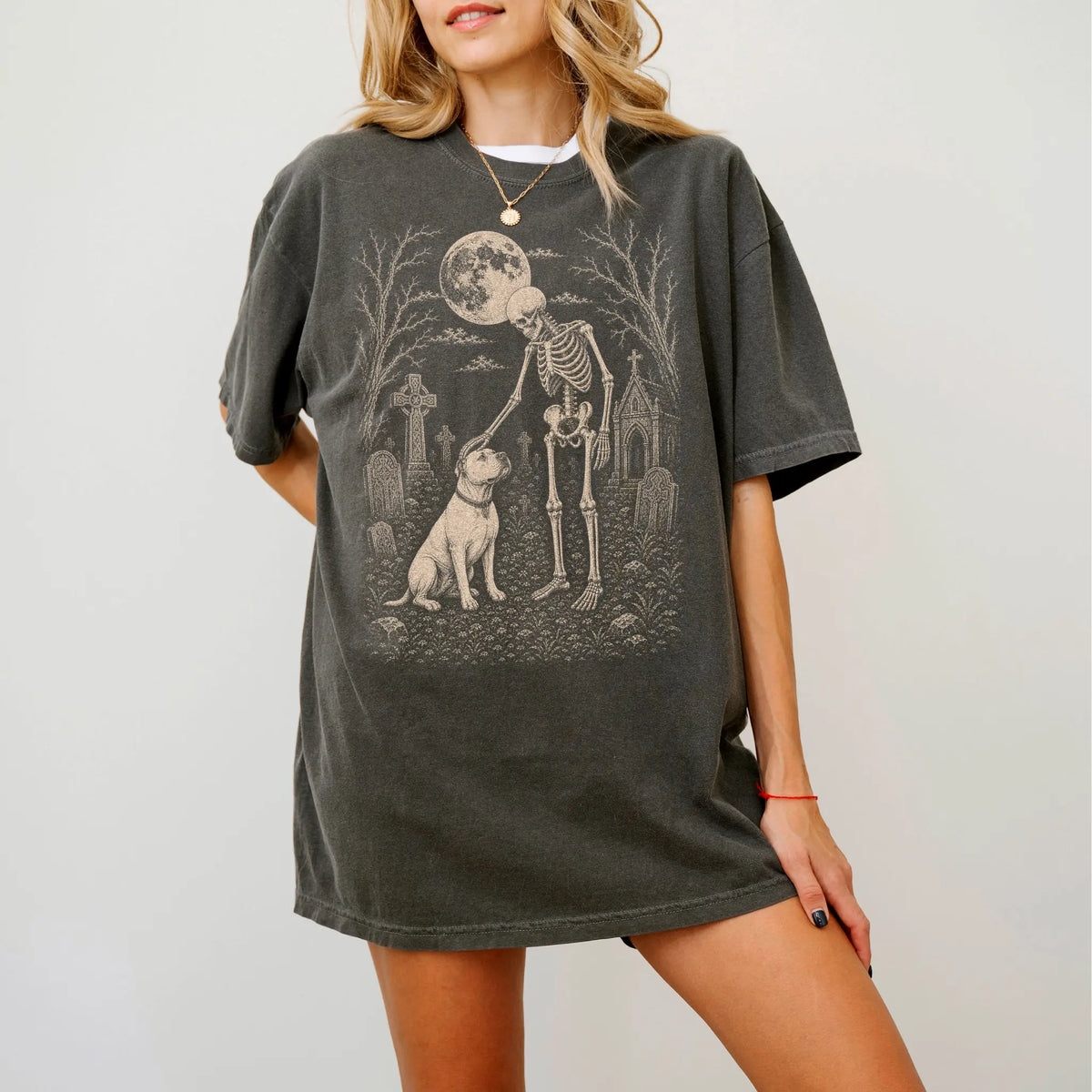 Model wearing a Pepper Comfort Colors® T-shirt showing American Bulldog sharing a quiet cemetery moment with a friendly skele