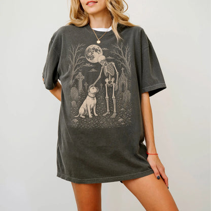 Model wearing a Pepper Comfort Colors® T-shirt showing American Bulldog sharing a quiet cemetery moment with a friendly skele