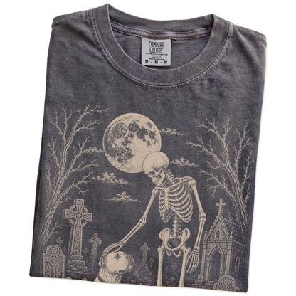 Folded Pepper Comfort Colors® T-shirt showing American Bulldog sharing a quiet cemetery moment with a friendly skeleton