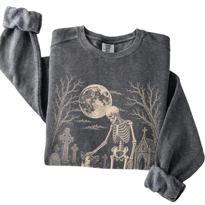 Folded Pepper sweatshirt with a skeleton petting a Belgian Malinois in a graveyard