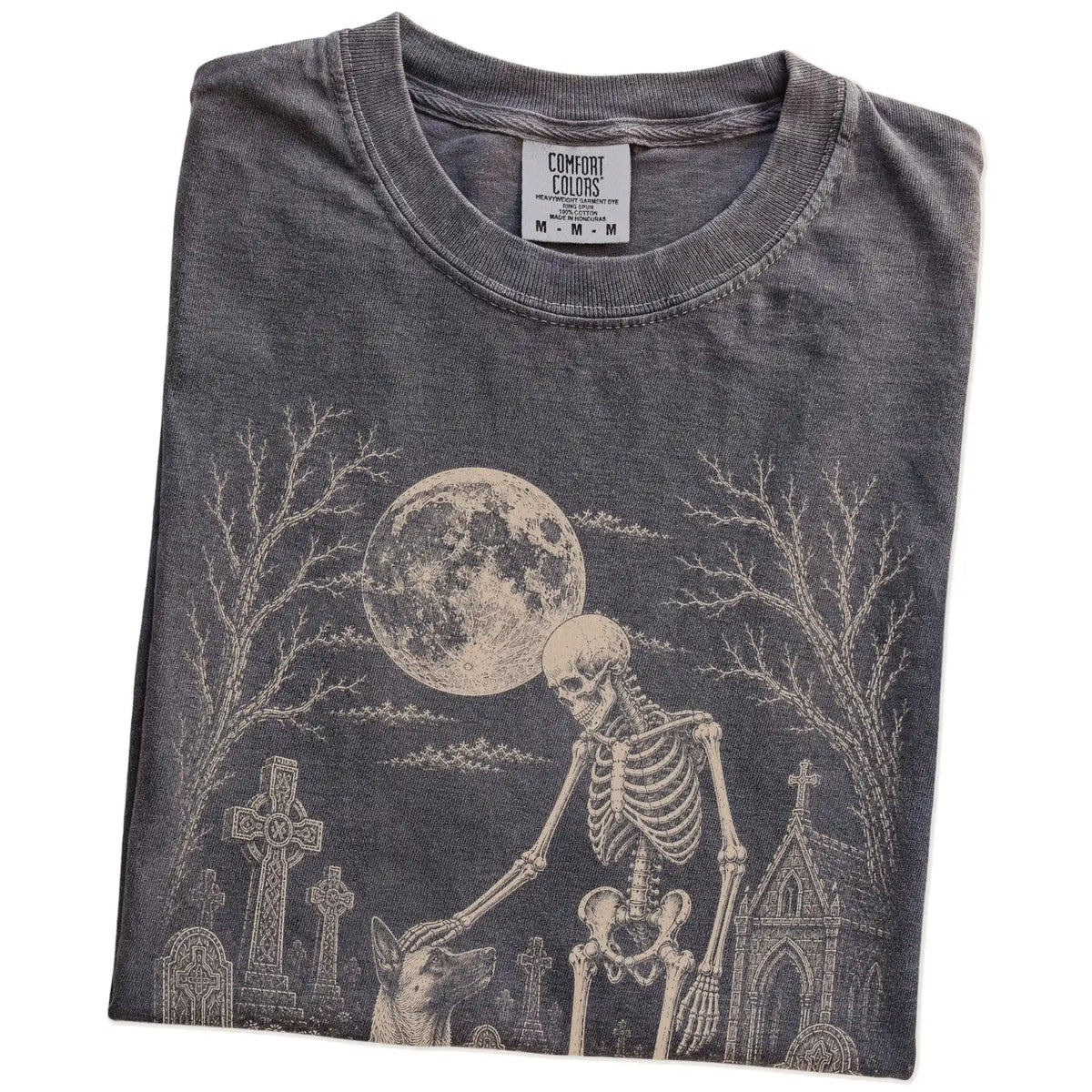 Folded Pepper Comfort Colors® T-shirt showing Belgian Malinois sharing a quiet cemetery moment with a friendly skeleton