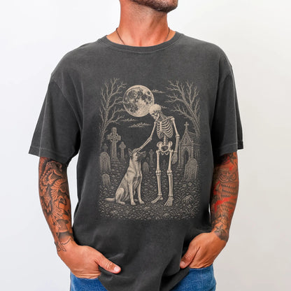 Model wearing a Pepper Comfort Colors® T-shirt showing Belgian Malinois sharing a quiet cemetery moment with a friendly skele