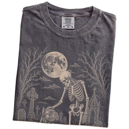 Folded Pepper Comfort Colors® T-shirt showing Cane Corso sharing a quiet cemetery moment with a friendly skeleton