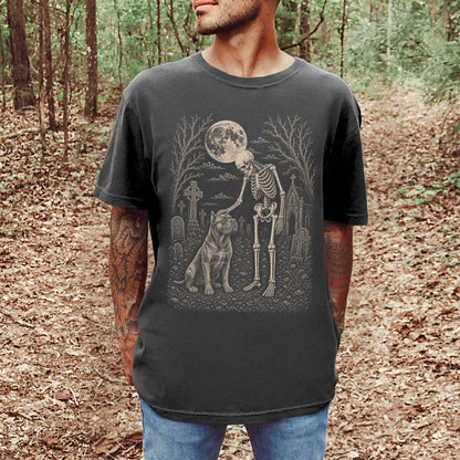 Model wearing a Pepper Comfort Colors® T-shirt showing Cane Corso sharing a quiet cemetery moment with a friendly skeleton
