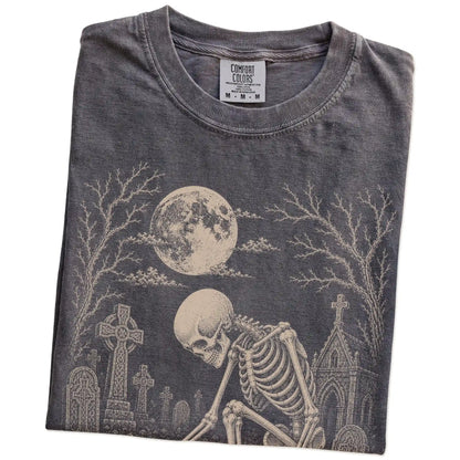 Folded Pepper Comfort Colors® T-shirt showing Chihuahua sharing a quiet cemetery moment with a friendly skeleton
