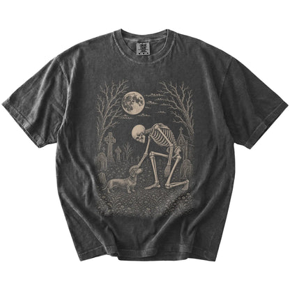 Dachshund sharing a quiet cemetery moment with a friendly skeleton on a Pepper Comfort Colors® T-shirt