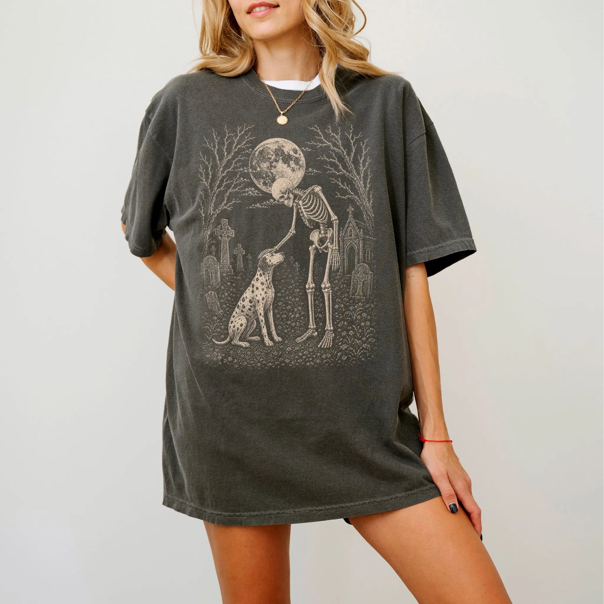 Model wearing a Pepper Comfort Colors® T-shirt showing Dalmatian sharing a quiet cemetery moment with a friendly skeleton