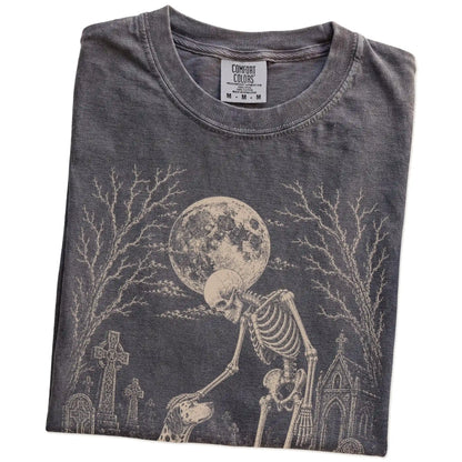 Folded Pepper Comfort Colors® T-shirt showing Dalmatian sharing a quiet cemetery moment with a friendly skeleton
