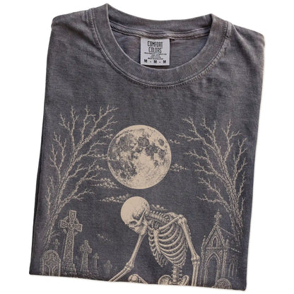 Folded Pepper Comfort Colors® T-shirt showing French Bulldog sharing a quiet cemetery moment with a friendly skeleton
