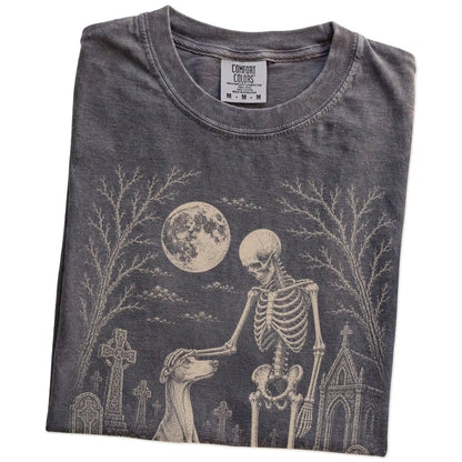 Folded Pepper Comfort Colors® T-shirt showing Greyhound sharing a quiet cemetery moment with a friendly skeleton