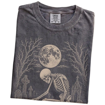 Folded Pepper Comfort Colors® T-shirt showing Jack Russell sharing a quiet cemetery moment with a friendly skeleton